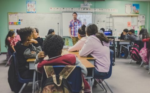 Niños y niñas atienden la explicación de su profesor en un aula